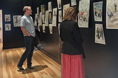 Visitors looking at Sam Marroquin's artwork in Seeking Warmth, photo by Sharon Svec.