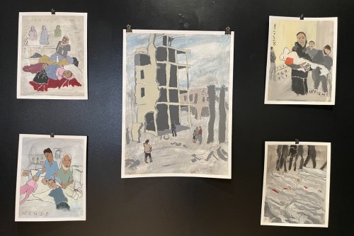 Sam Marroquin's paintings hanging on a black gallery wall.