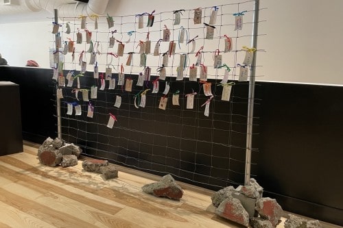A fence covered with tags in an installation artwork by Sam Marroquin.