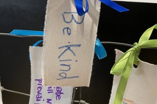 Be kind, written on a tag as part of an interactive  installation artwork.