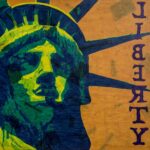 Painting of the face of the Statute of Liberty in yellow , green and blue on an orange background with Liberty written in reversed text.