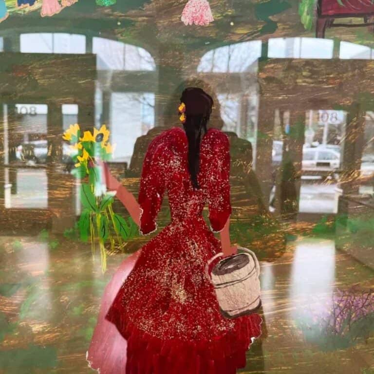 Painting by Ceija Stojka titled The Mama of a lady in a red dress holding yellow sunflowers on a green background with the reflection of the gallery on the glass photo by Friderike Heuer.