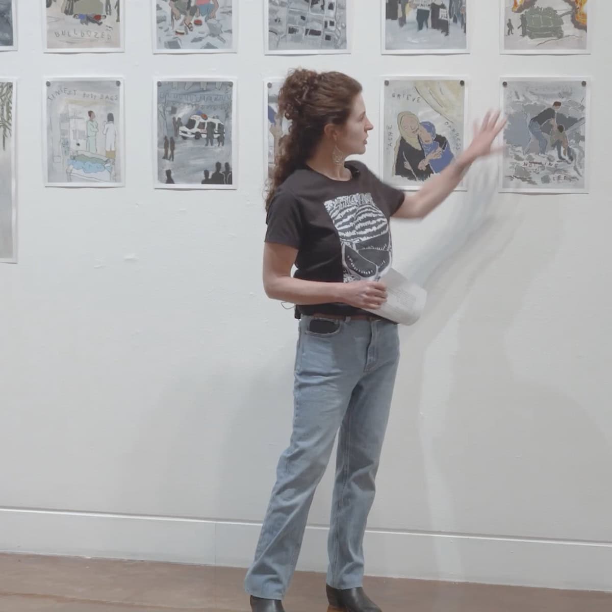 Artist Sam Marroquin stands in front of her artwork in an art gallery.